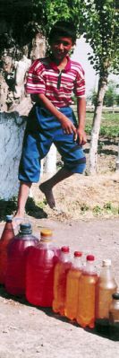 A boy sells smuggled fuel in Kyrgyz Republic, by-passing taxation